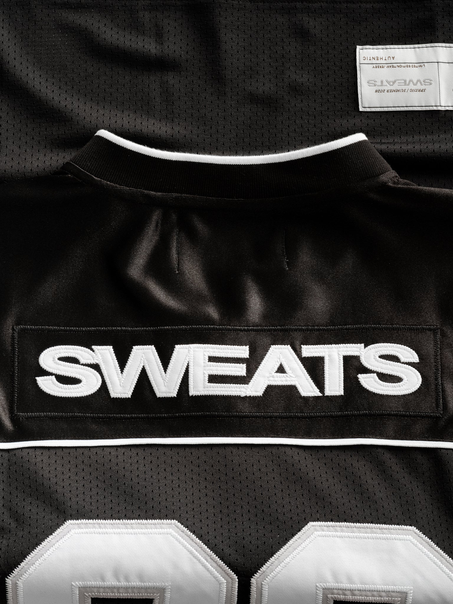 Black Signature Jersey by Sweats UK displayed flat, showcasing its sleek design and comfortable fit.