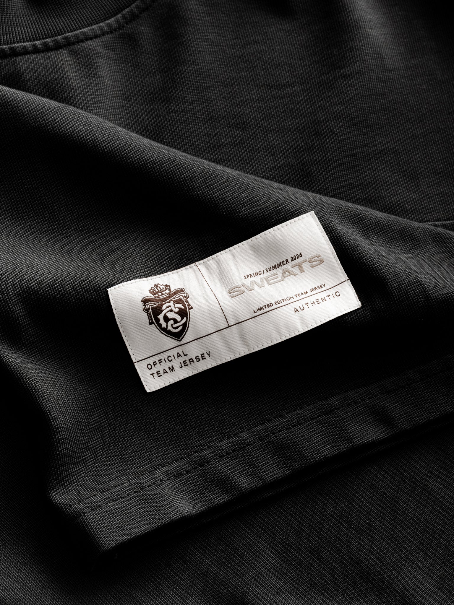 Washed black long-sleeve jersey T-shirt by Sweats UK displayed flat with visible fabric texture and classic fit style.
