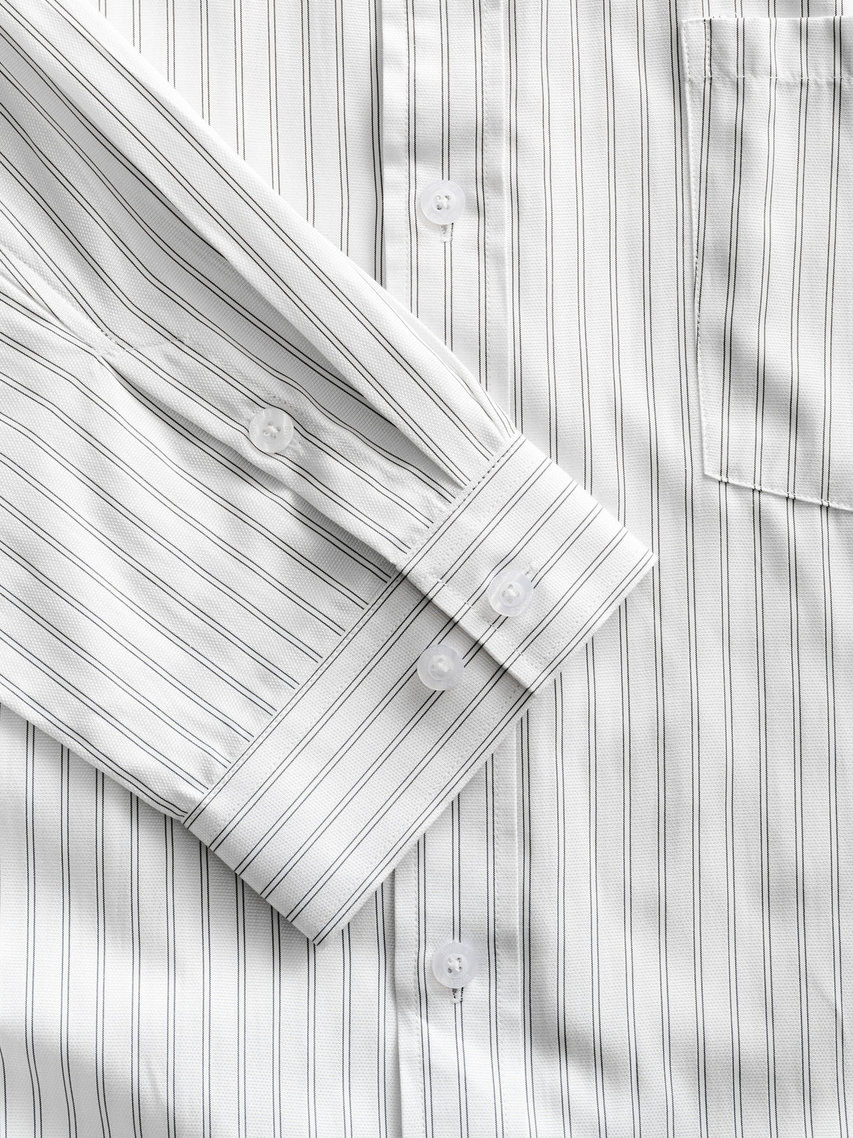 White striped button-up shirt by Sweats UK, neatly folded with visible collar and button details.