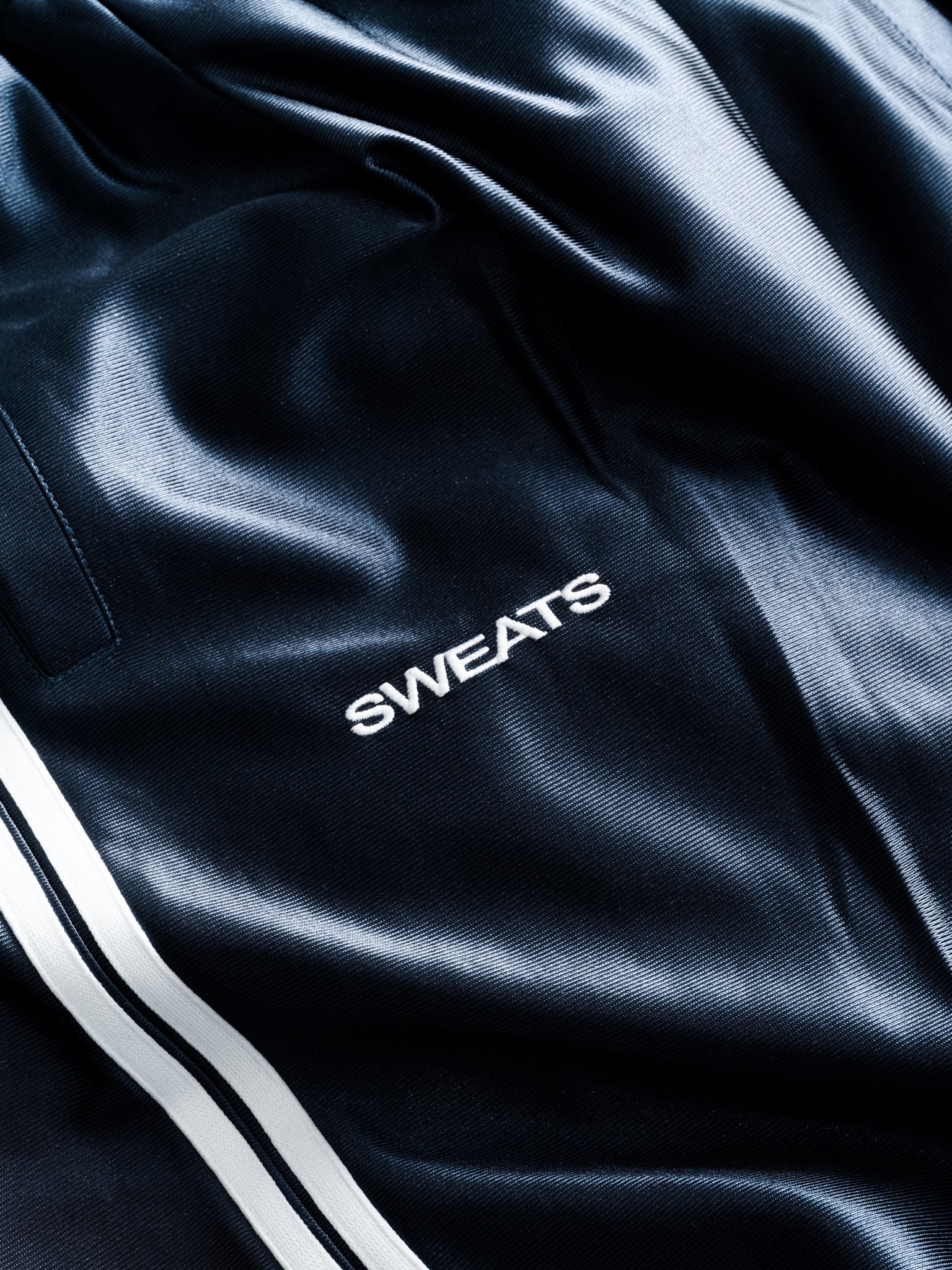Navy League Shorts from Sweats UK laid flat, featuring a comfortable elastic waistband and sporty design for casual wear.