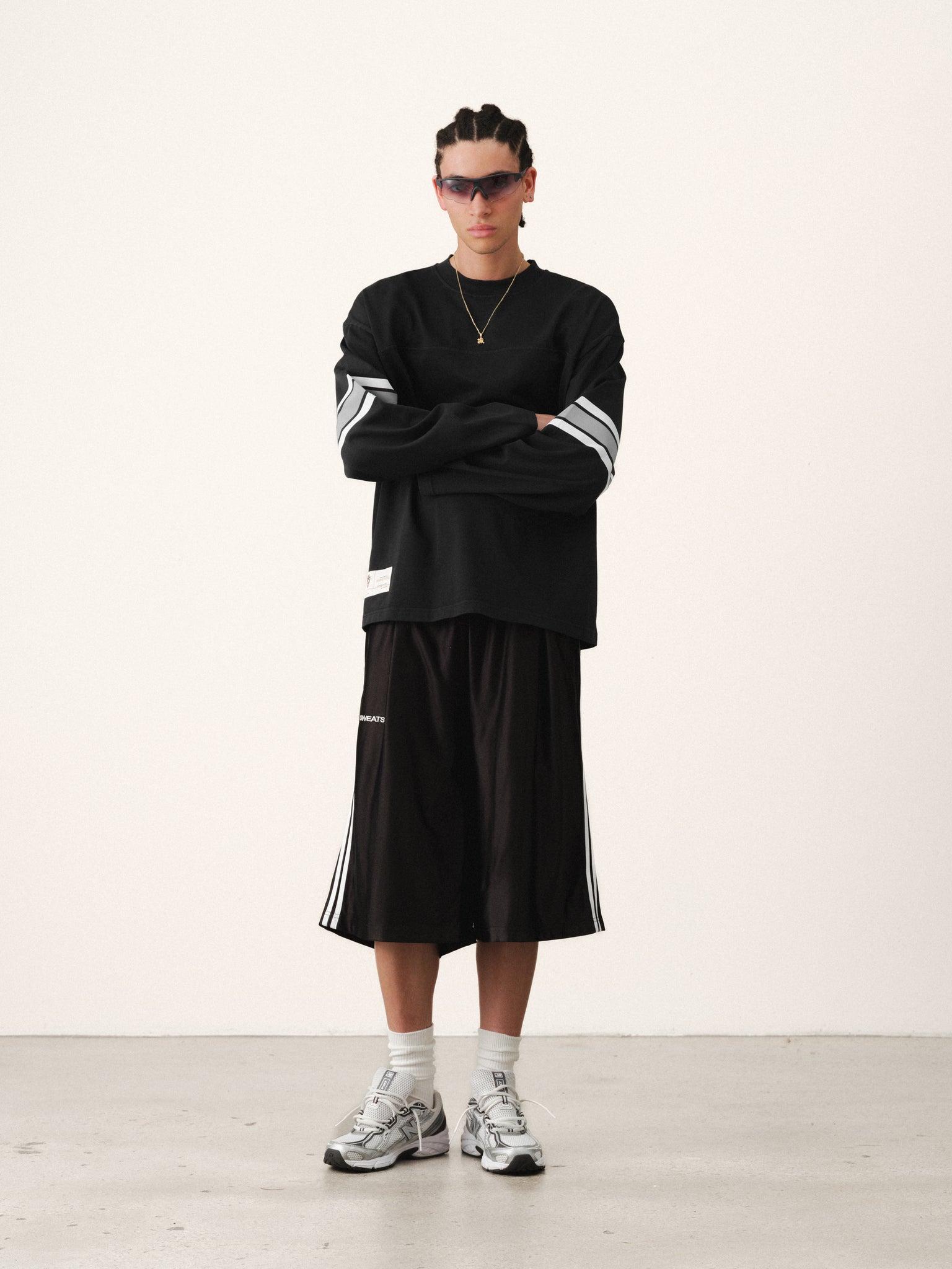 Washed black long-sleeve jersey T-shirt by Sweats UK displayed on a hanger against a white background.