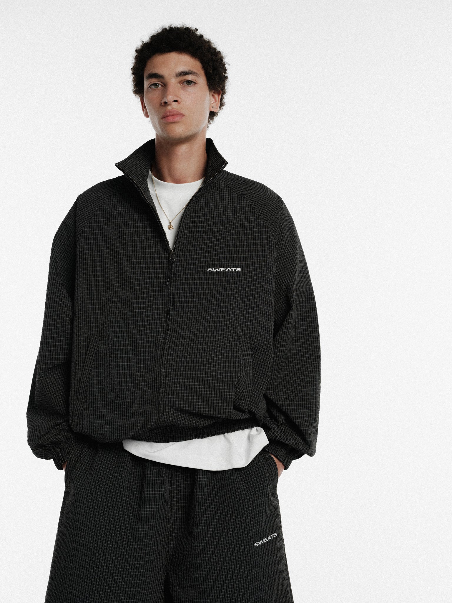 Black and white checkered track jacket by Sweats UK, featuring a sporty design and full-length sleeves.