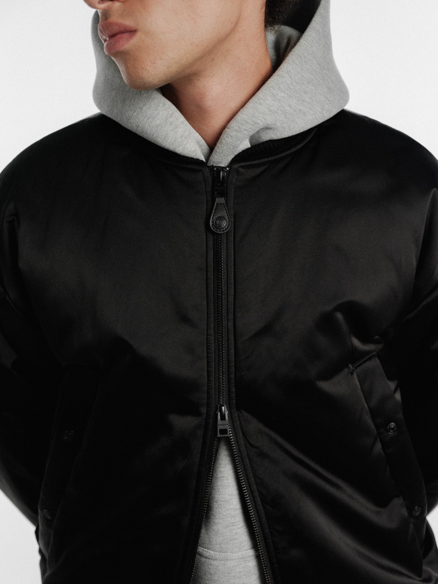Black bomber jacket by Sweats UK, featuring a stylish design with ribbed cuffs and collar, displayed on a hanger.