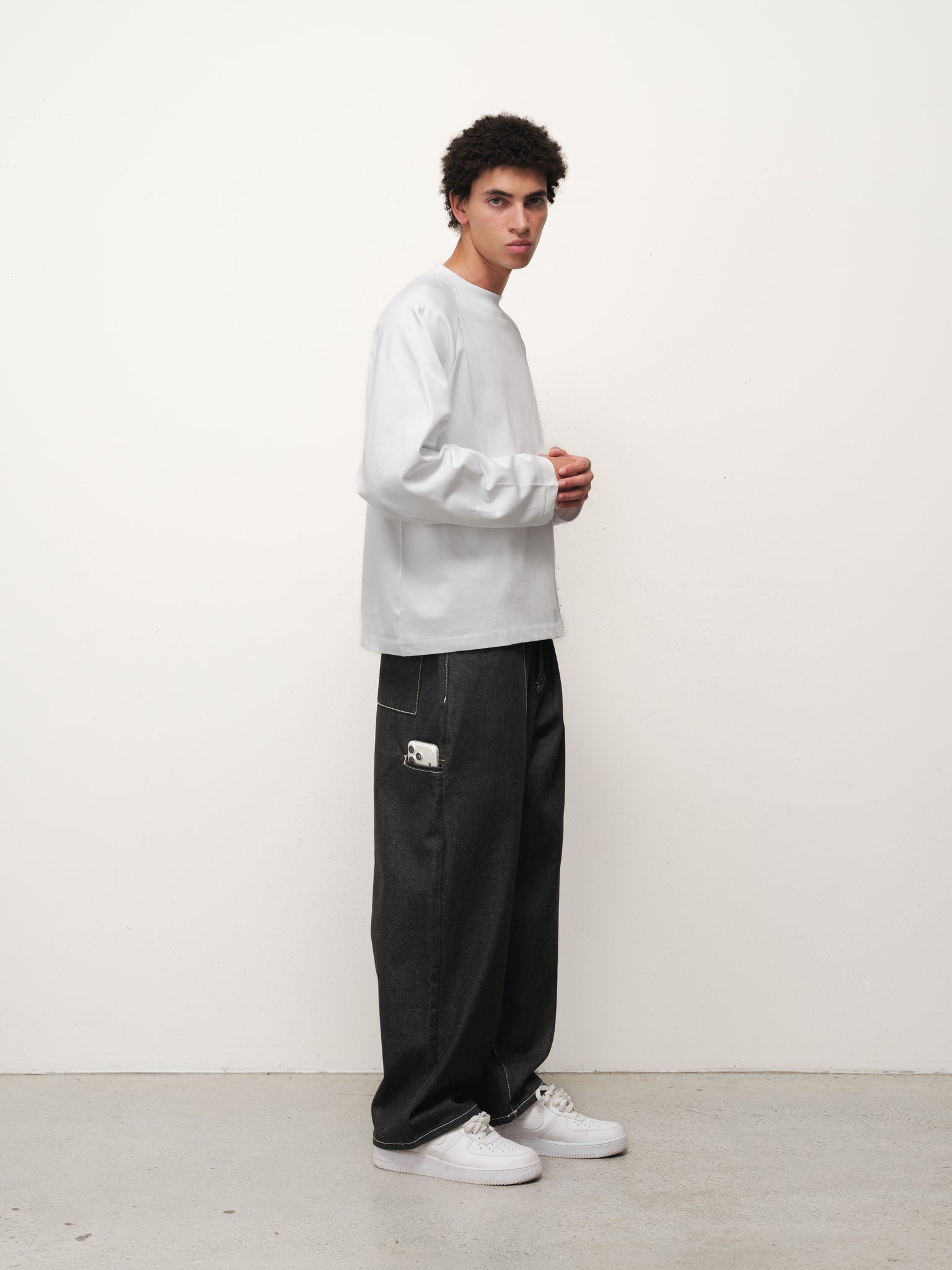 White long sleeve T-shirt by Sweats UK displayed flat with sleeves extended and neckline visible, showcasing casual men's or women's apparel.