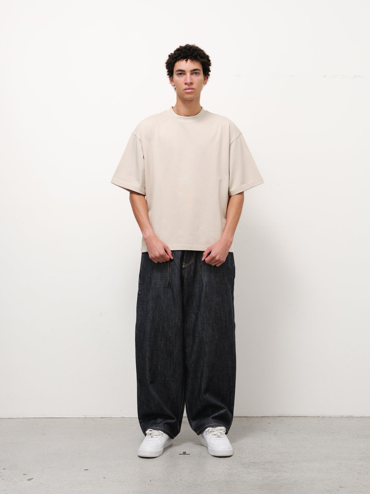 Sweats UK denim baggy jeans in indigo color, relaxed fit with classic five-pocket design and belt loops, front and back view.