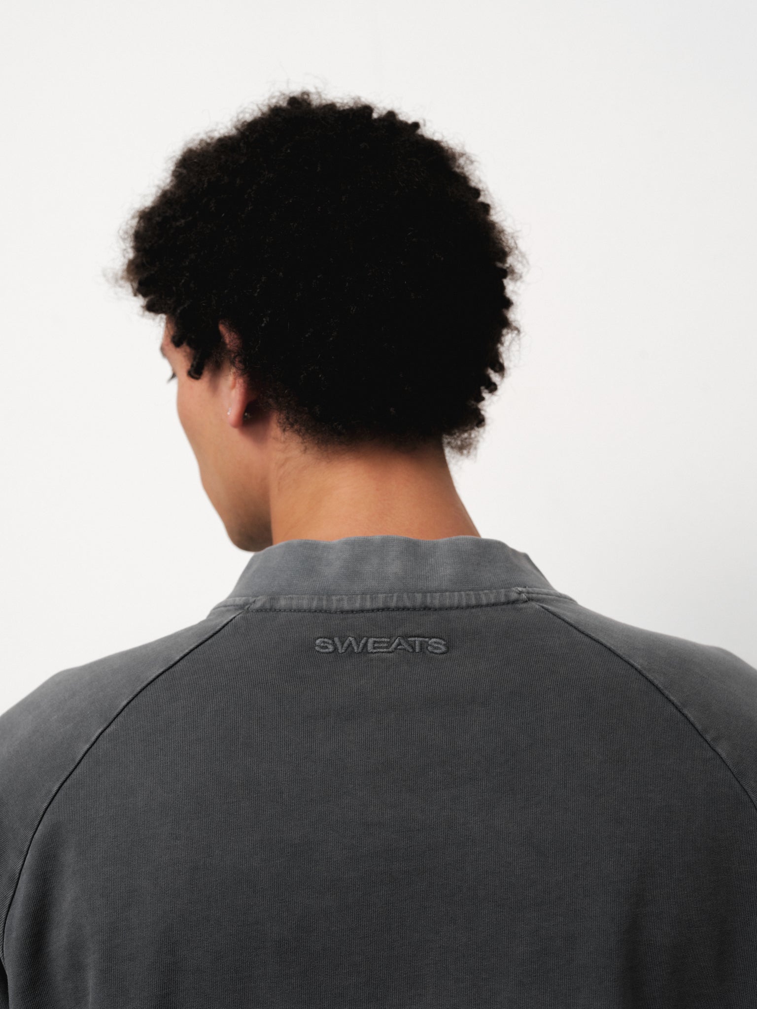 Washed grey long sleeve T-shirt from Sweats UK displayed on a model, featuring a relaxed fit and soft fabric.