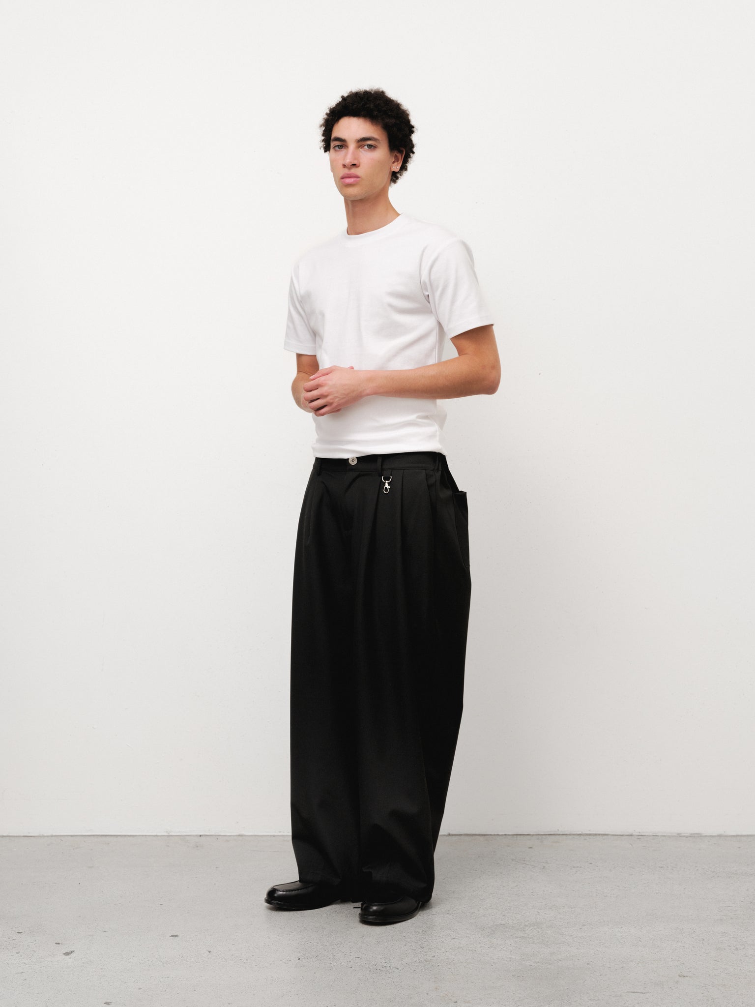 White fitted T-shirt by Sweats UK displayed on a model, showcasing a casual, slim-fit design perfect for everyday wear.
