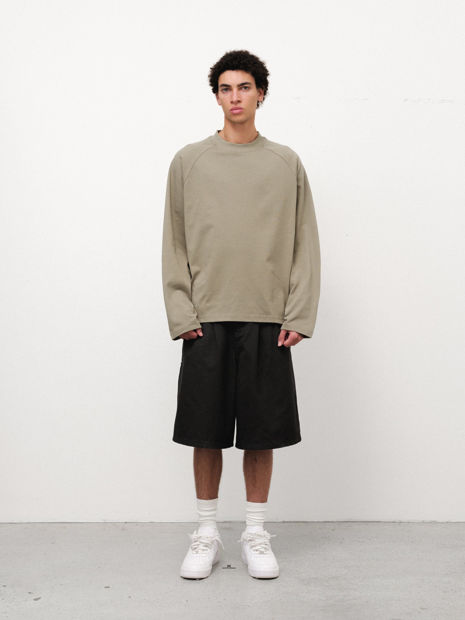 Long sleeve sage T-shirt by Sweats UK displayed on a model, featuring a comfortable fit and casual style.