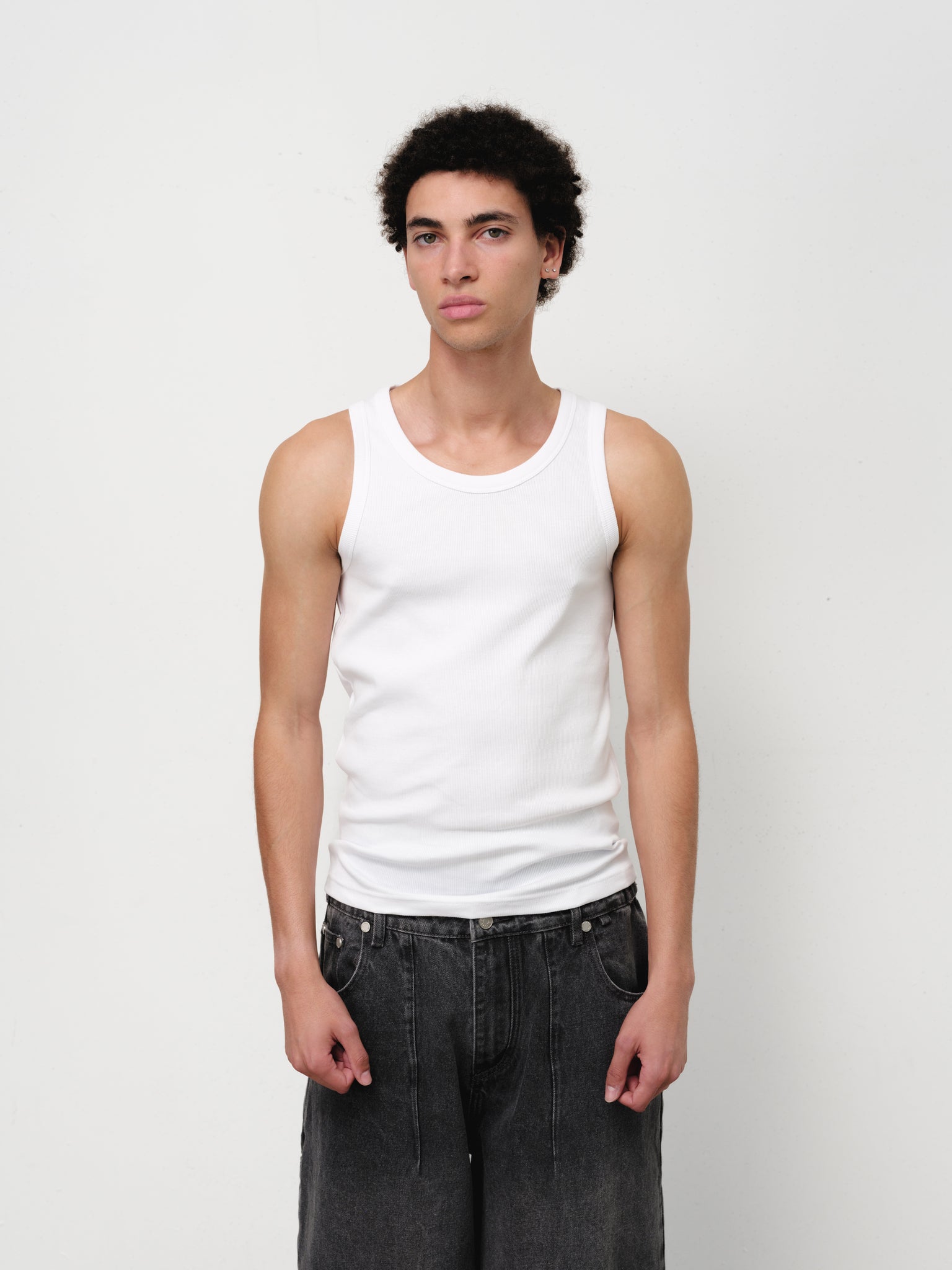 White tank singlet from Sweats UK, displayed flat with shoulder straps and a simple, clean design.