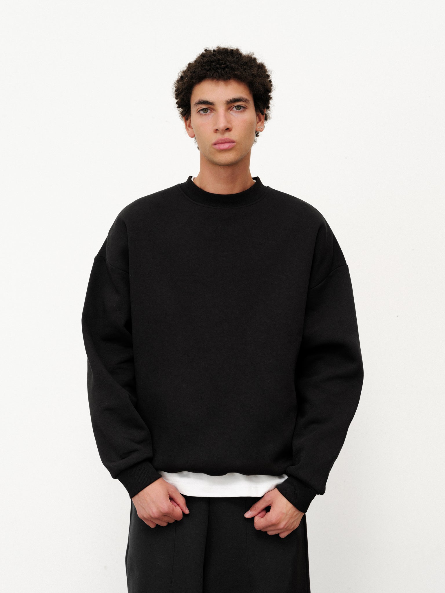 Black cozy sweater by Sweats UK, displayed flat showing its soft knit fabric and classic fit.