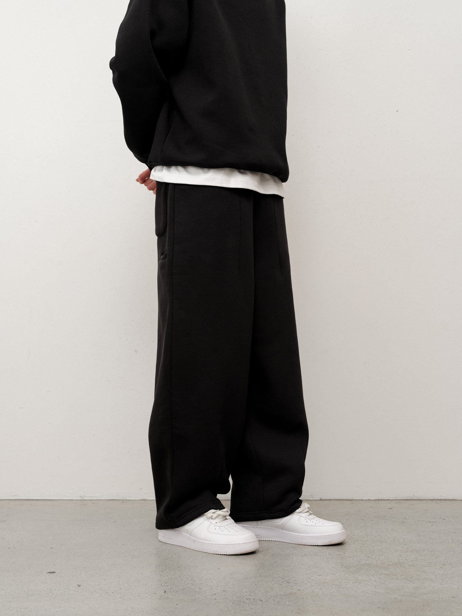 Black cozy straight-leg sweatpants by Sweats UK, shown folded with an elastic waistband and soft fabric texture.