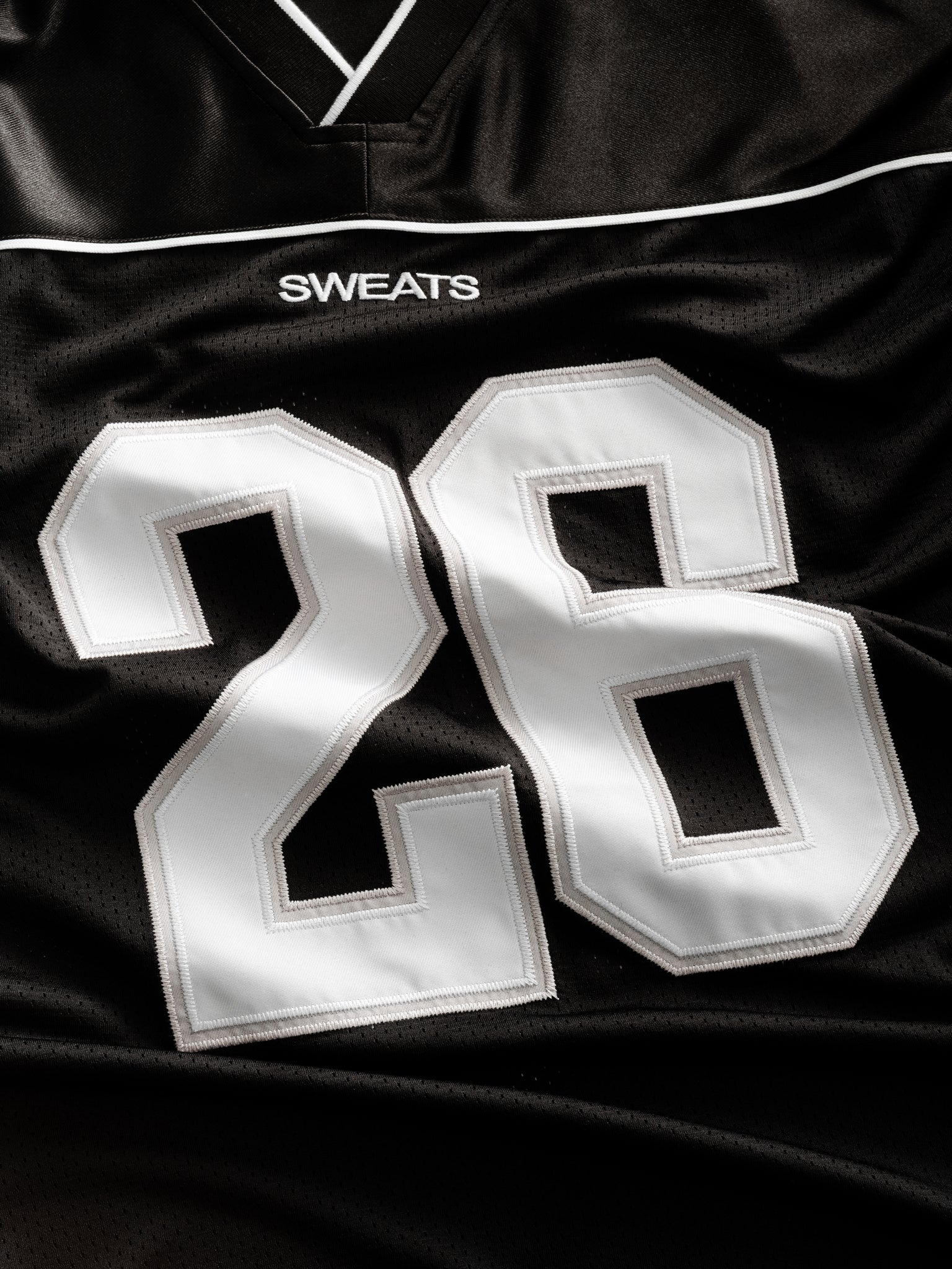 Black Signature Jersey from Sweats UK displayed flat, showcasing its sleek design and soft fabric for comfortable casual wear.