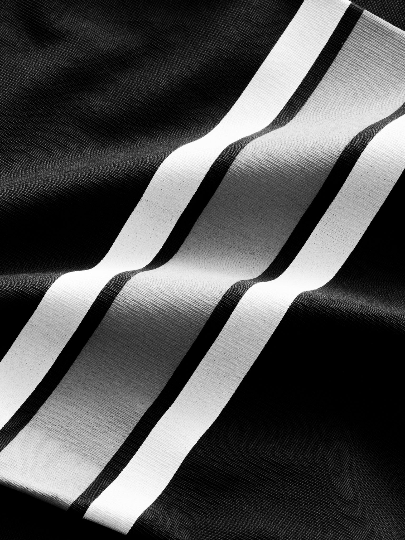 Washed black long-sleeve jersey T-shirt from Sweats UK displayed flat with visible stitching and soft fabric texture.