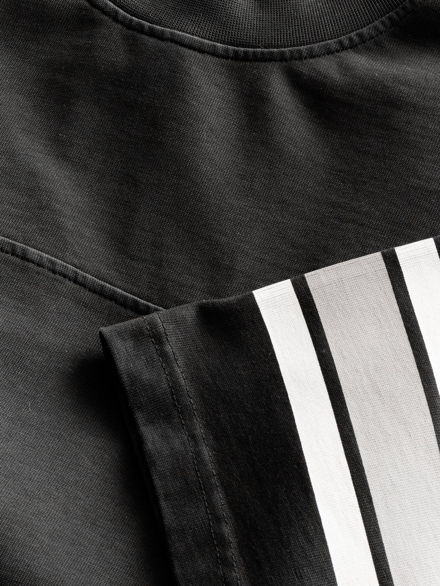 Washed black Sweats UK short sleeve jersey T-shirt laid flat, showcasing its simple, casual design and soft fabric texture.