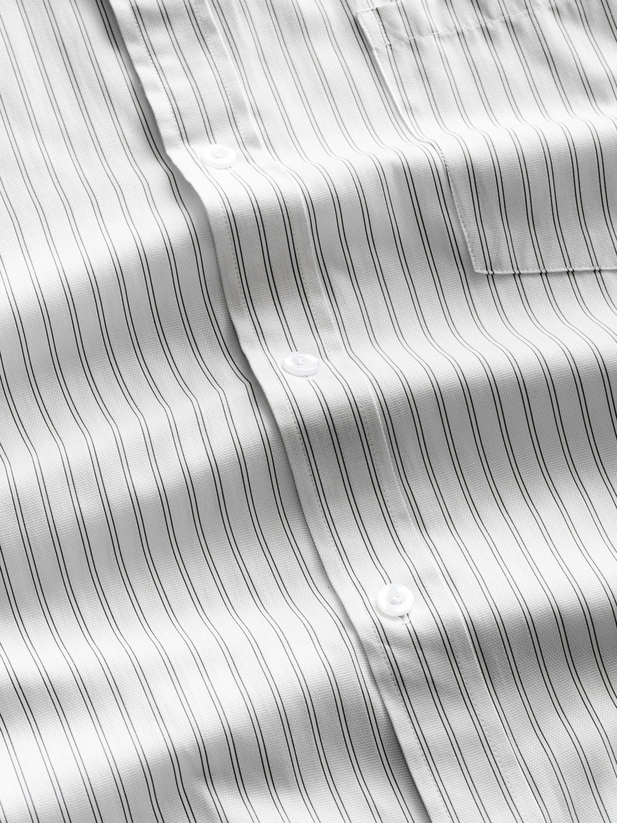 White striped button-up shirt by Sweats UK, laid flat showing collar, buttons, and classic design.