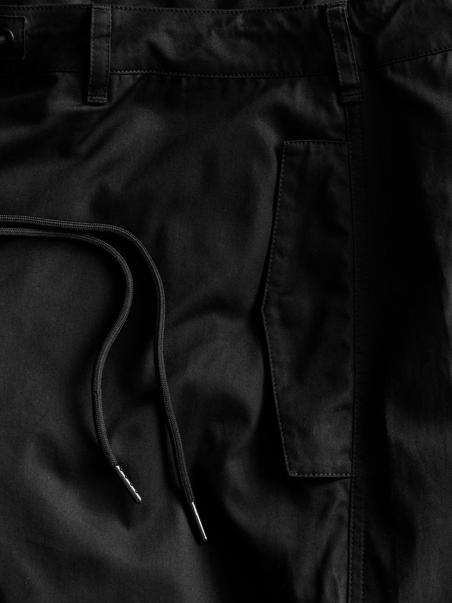 Black V3 Flight Pant by Sweats UK laid flat, showcasing the relaxed fit, adjustable waistband, and sleek design.