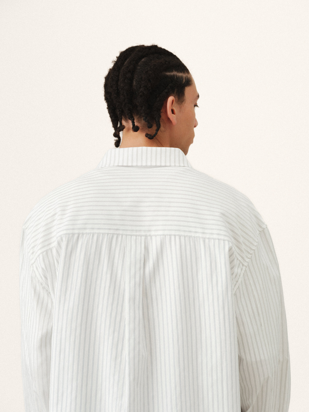 White striped button-up shirt by Sweats UK, showing the front view with a classic collar and button details.