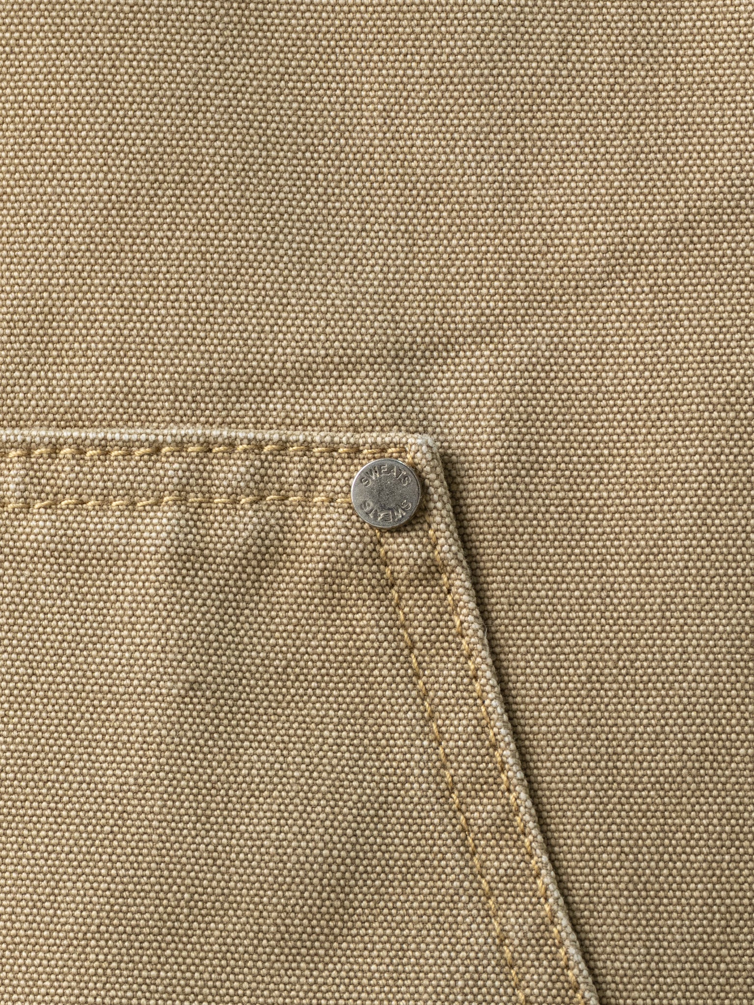 Double knee sand-colored pants by Sweats UK featuring a relaxed fit and stylish design, shown on a model in the image.