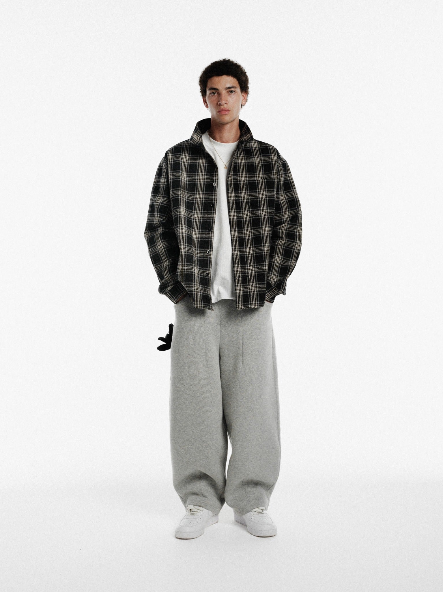 Black long-sleeve flannel shirt by Sweats UK, shown laid flat with button-up front and classic collar.