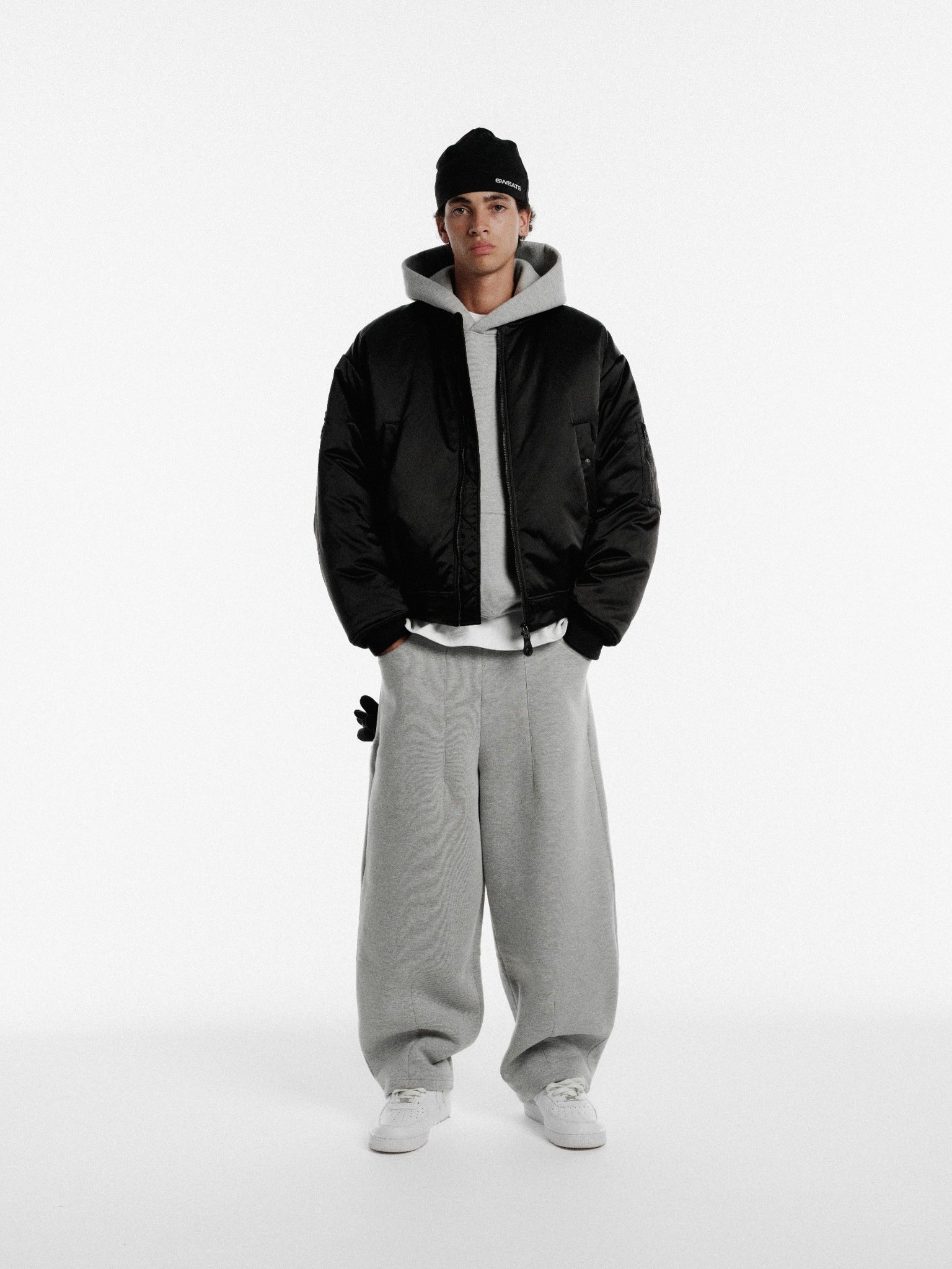 Black bomber jacket from Sweats UK with a sleek design, featuring ribbed cuffs and a front zipper for a stylish winter look.