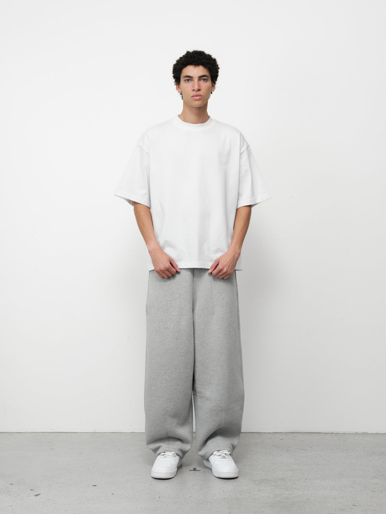 Pure white Signature blank T-shirt by Sweats UK displayed on a hanger against a neutral background.