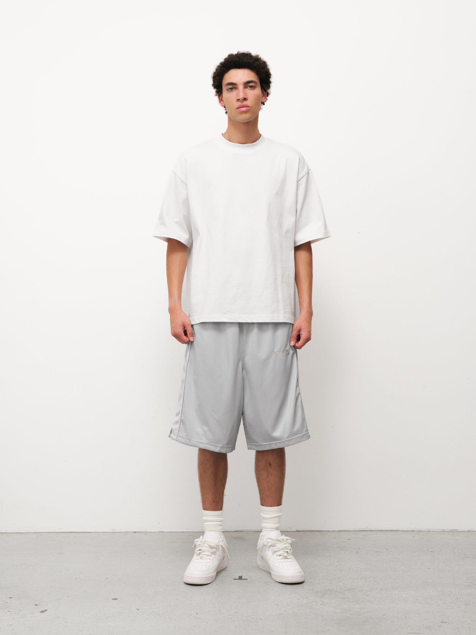 Gray mesh shorts by Sweats UK, featuring breathable fabric and a relaxed fit, ideal for casual or athletic wear.