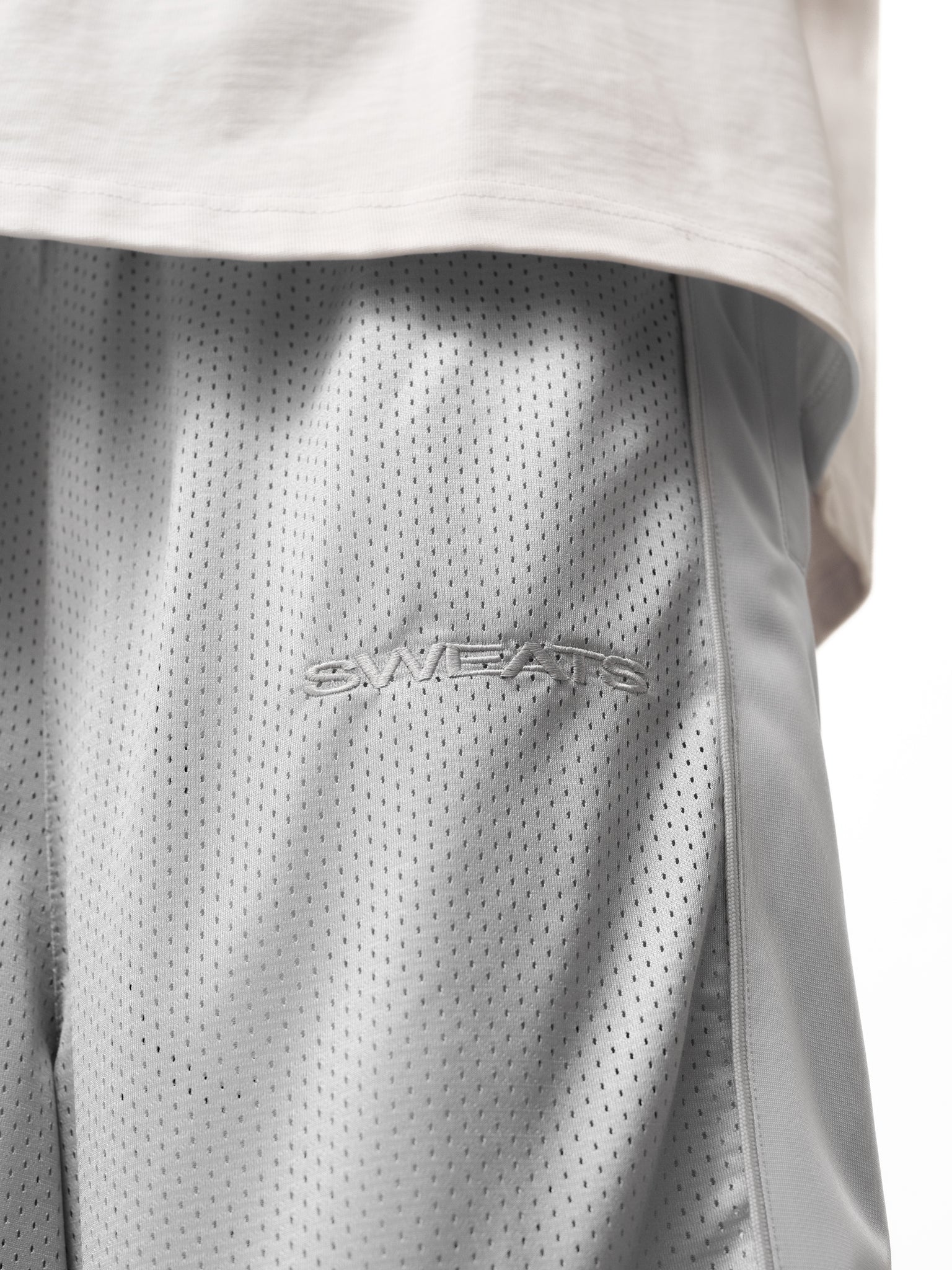 Gray mesh shorts by Sweats UK, featuring lightweight breathable fabric, elastic waistband, and casual fit.