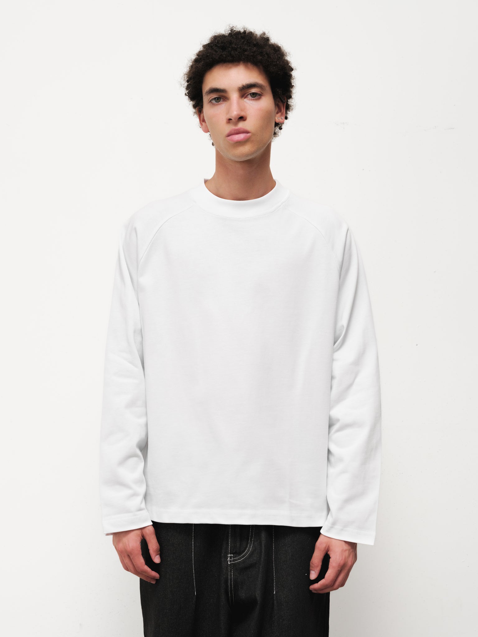White long sleeve T-shirt by Sweats UK displayed flat, showing the simple design and soft fabric texture.