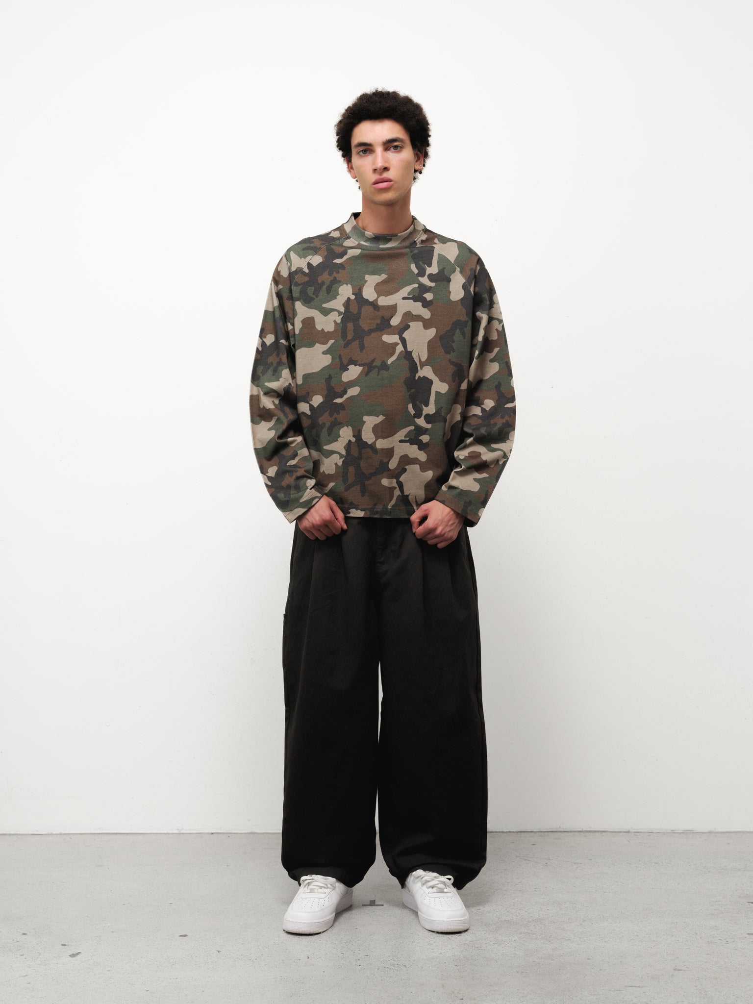 Long sleeve camo t-shirt by Sweats UK displayed on a mannequin with a forest green and brown camouflage pattern.