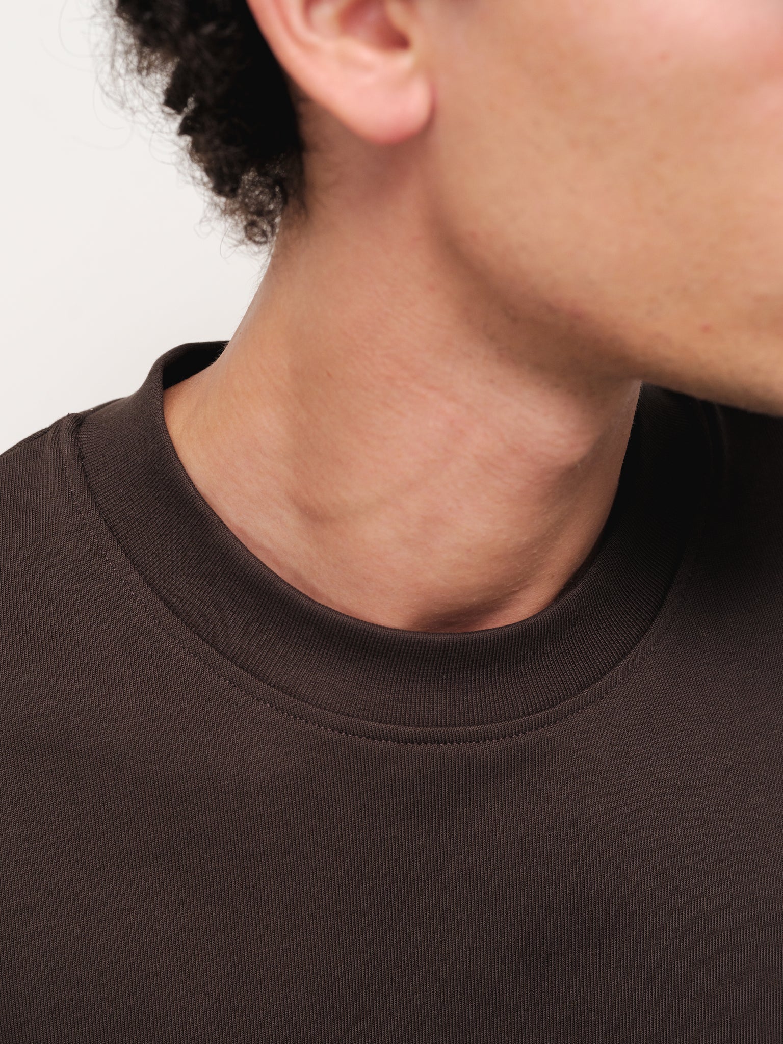 Sweats UK Signature blank coffee-colored T-shirt displayed on a hanger, showcasing the casual, minimalist design and fabric texture.