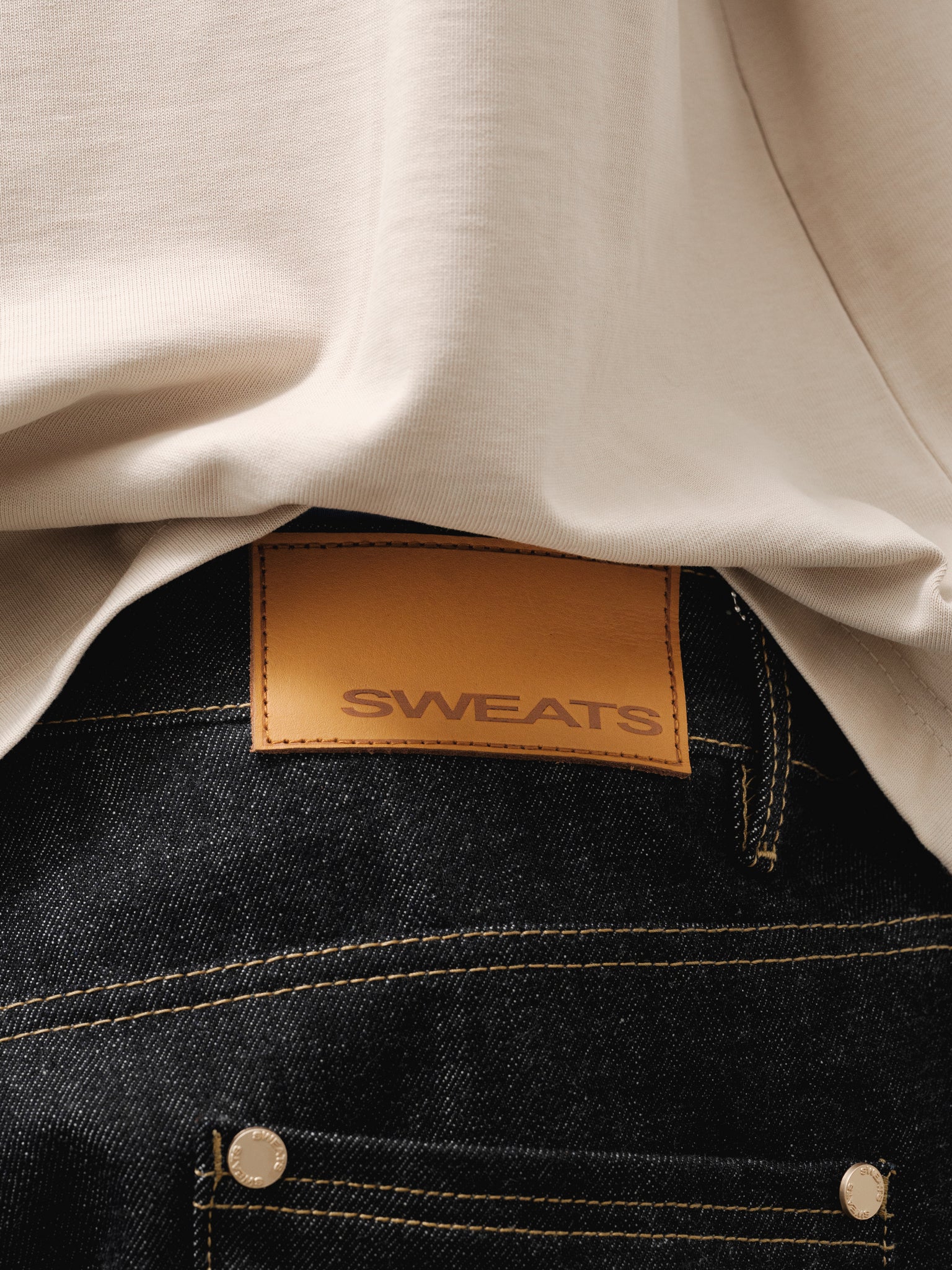 Pair of indigo denim baggy jeans by Sweats UK showing relaxed fit and classic five-pocket design.