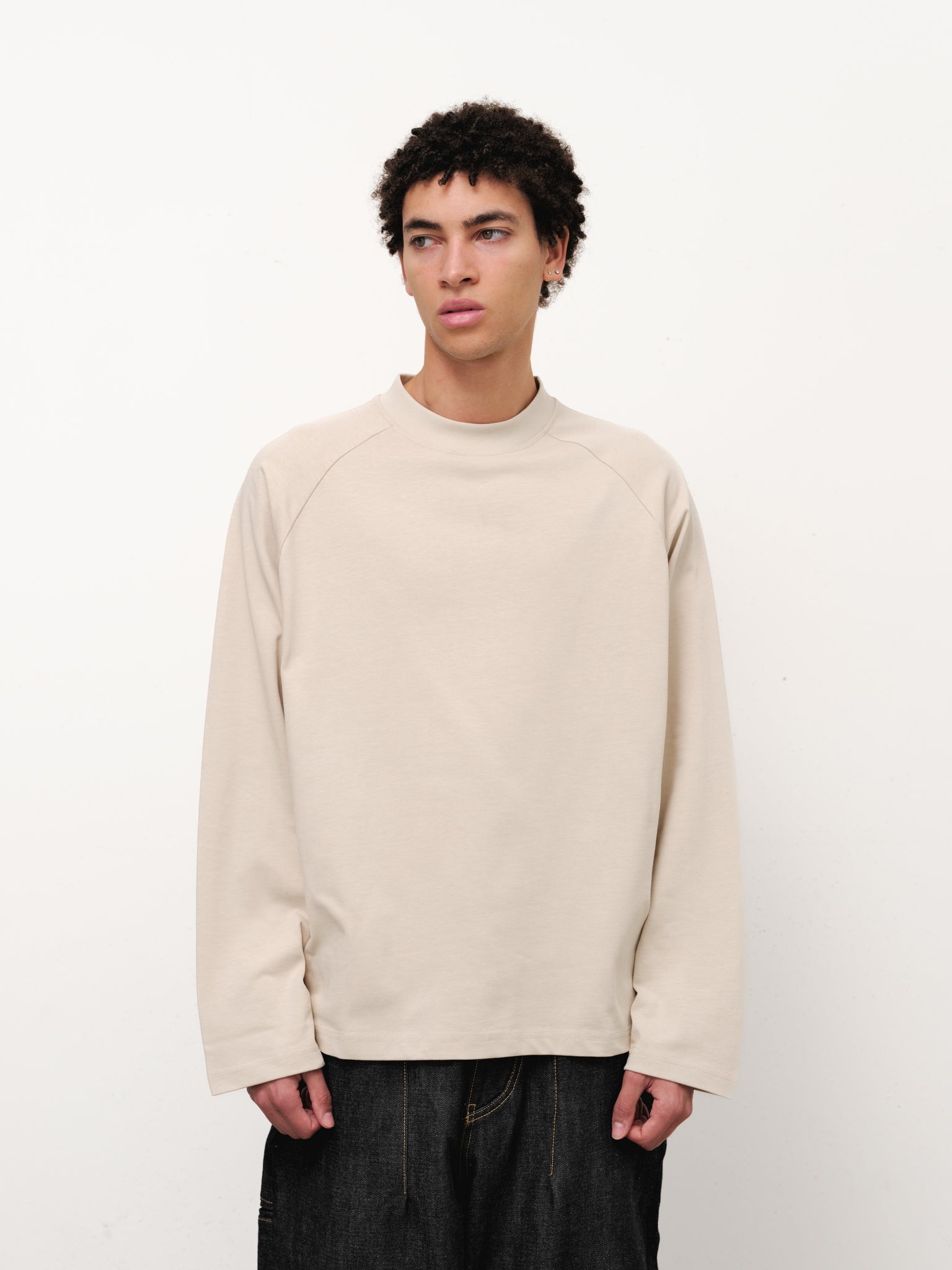 Oat-colored long sleeve T-shirt by Sweatscollective-UK displayed on a model, showcasing a casual fit and soft fabric.