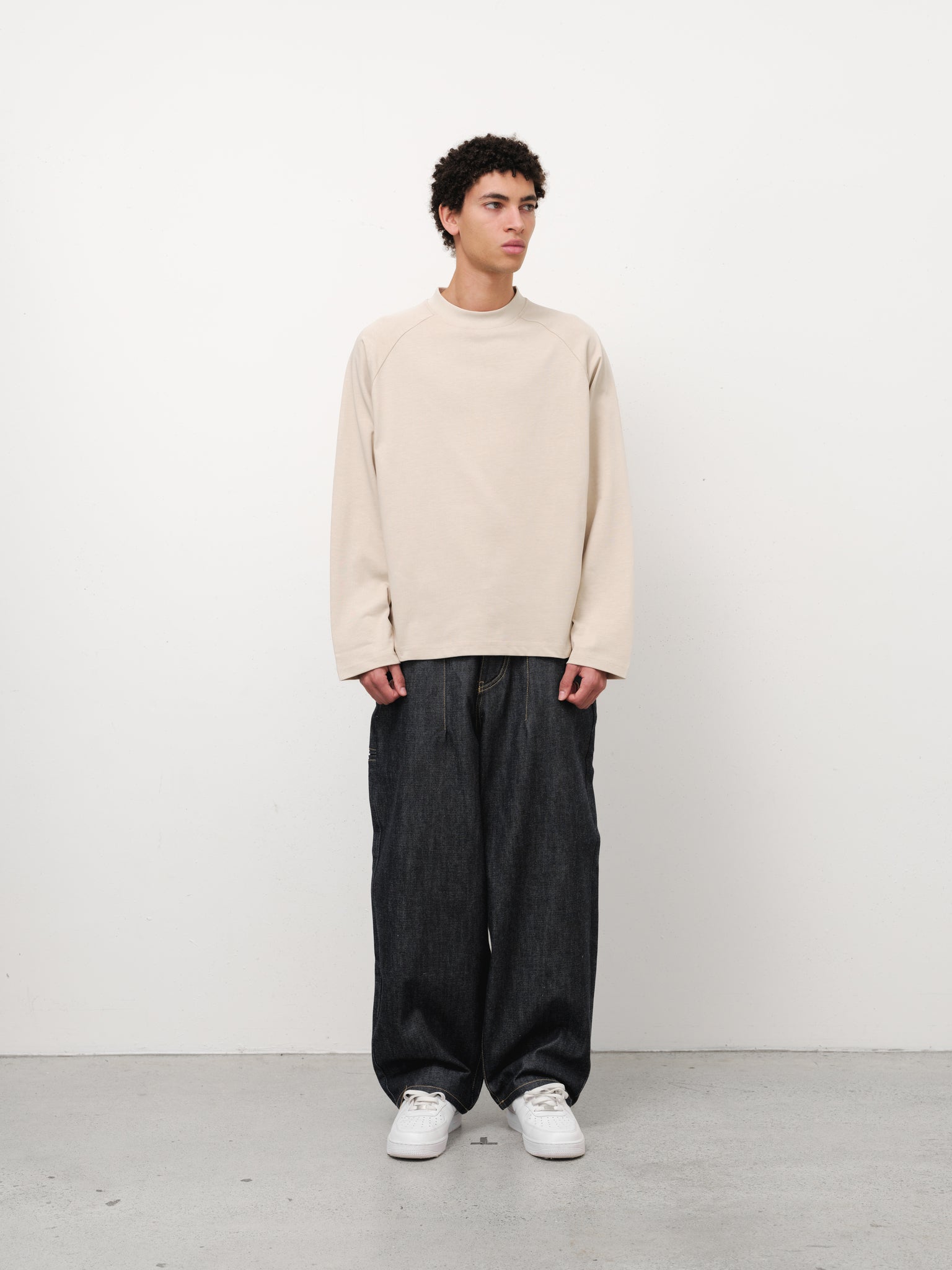 Oat-colored long sleeve t-shirt from Sweats Collective UK displayed on a model, showing the casual, comfortable fit and fabric texture.