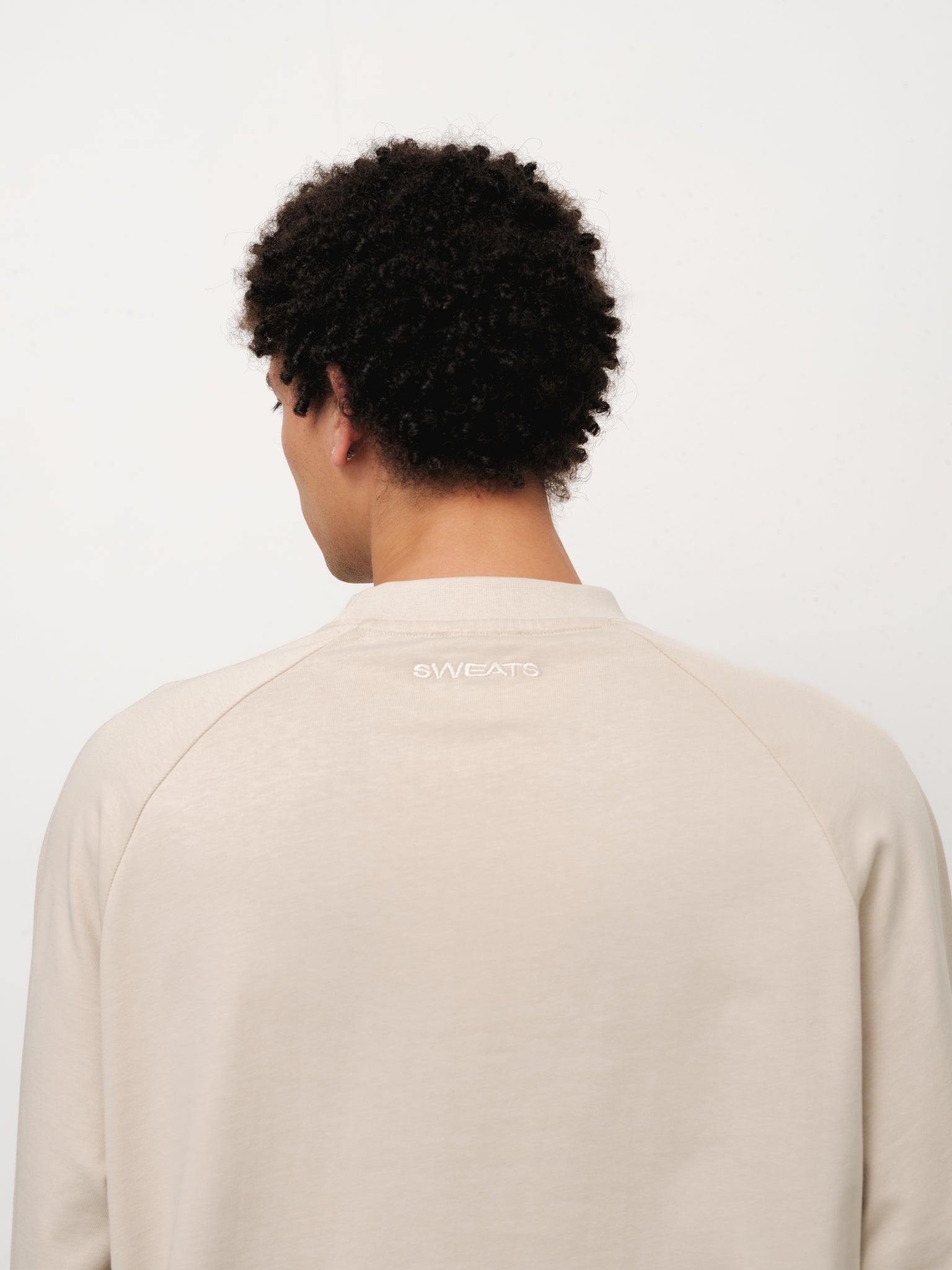 Long sleeve oat-colored T-shirt from SweatsCollective-UK displayed on a model, showcasing casual fit and soft fabric.